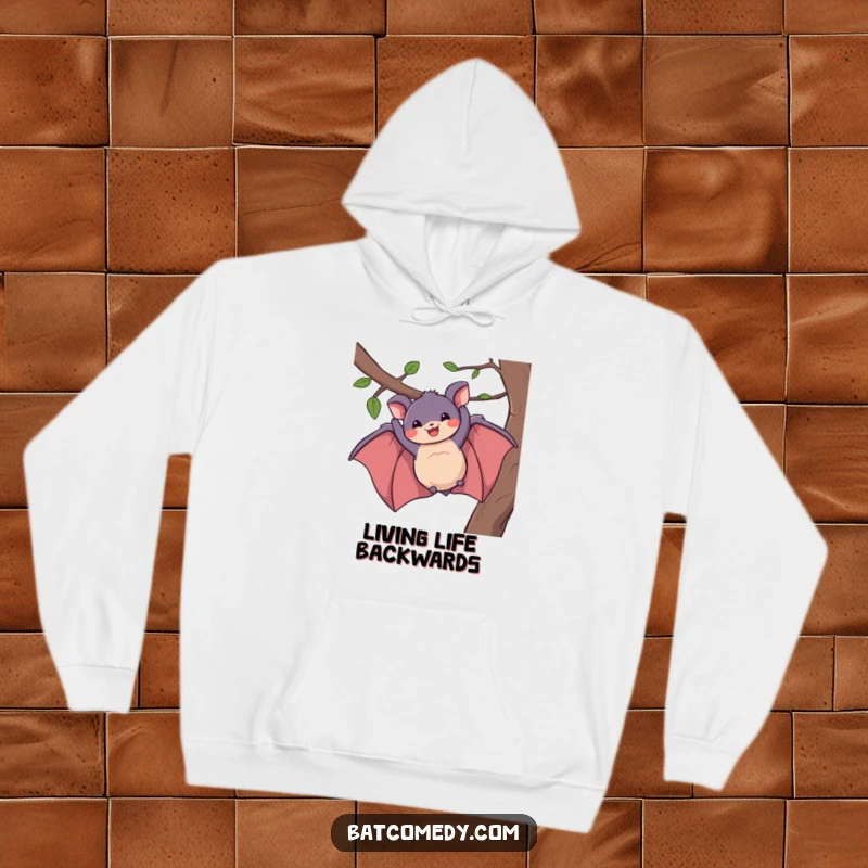 Funny hoodie of a bat dangling from a branch with a huge, happy grin, providing warmth and humor.